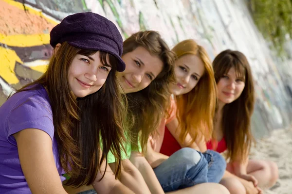Vier vriendinnen in de buurt van graffiti muur. — Stockfoto