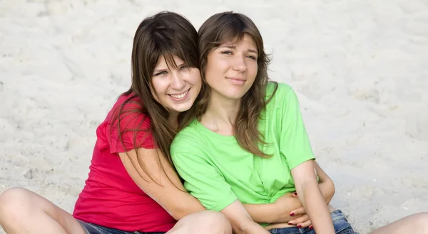Twee vriendinnen in sand. — Stockfoto