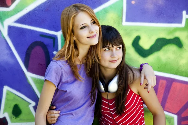 Twee vriendinnen in de buurt van graffiti muur. — Stockfoto