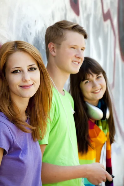 Teens with headphones near graffiti wall. — Stock Photo, Image