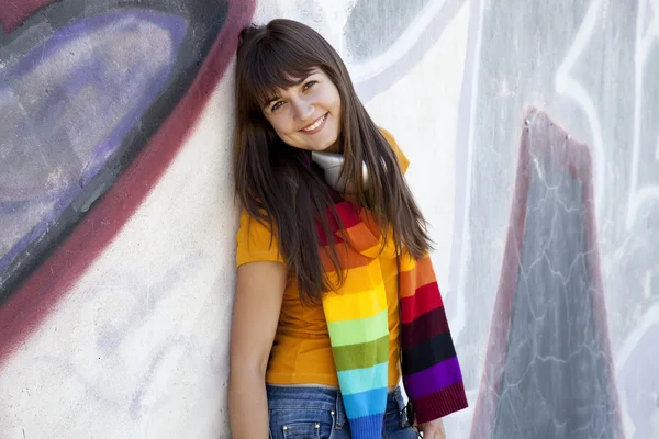 Krásná brunetka s sluchátka a graffiti zeď na bac — Stock fotografie