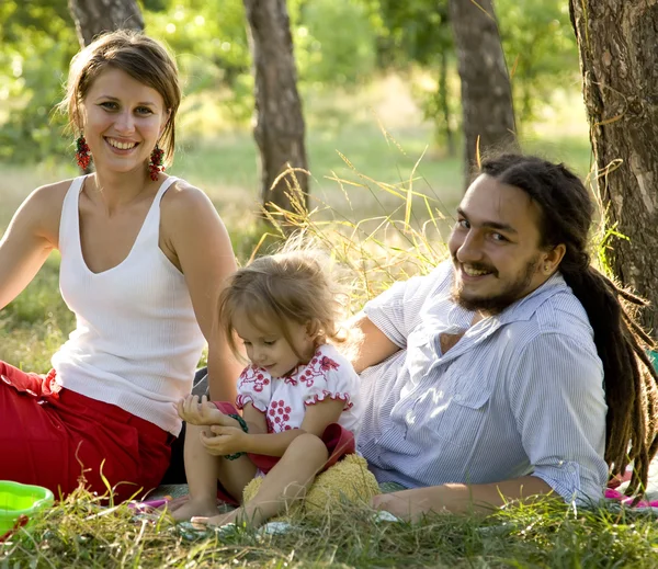 Ευτυχισμένη οικογένεια στο καλοκαιρινό πάρκο — Φωτογραφία Αρχείου