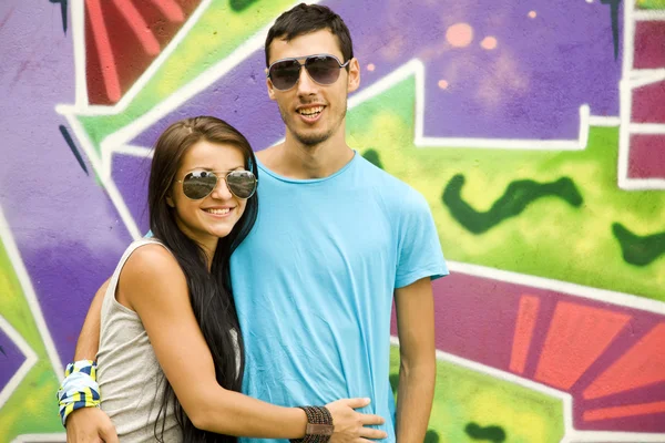 Ζευγάρι με σημειωματάριο κοντά γκράφιτι τοίχο. — Φωτογραφία Αρχείου
