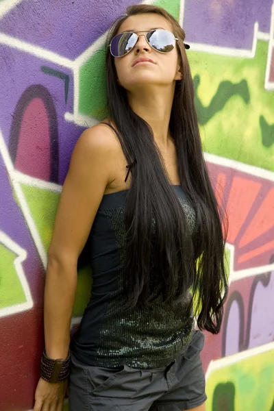 Flicka nära graffiti bakgrund. — Stockfoto
