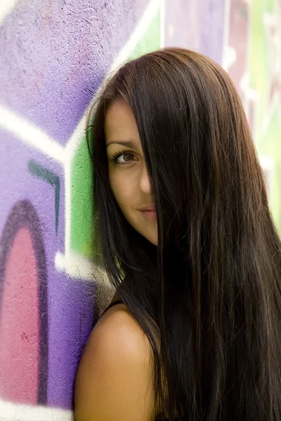 Dziewczyna w pobliżu graffiti tło. — Zdjęcie stockowe