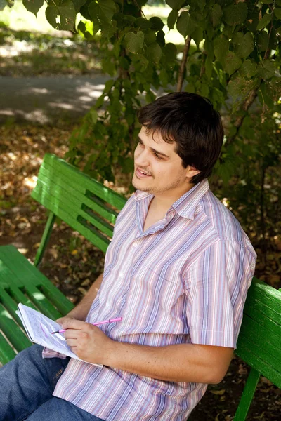 Men with glasses doing homework at the park. — Stock Photo, Image