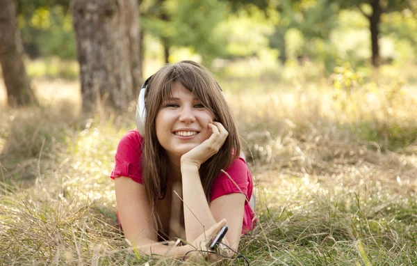 Μελαχρινή κοπέλα με ακουστικών στο πάρκο. — Φωτογραφία Αρχείου