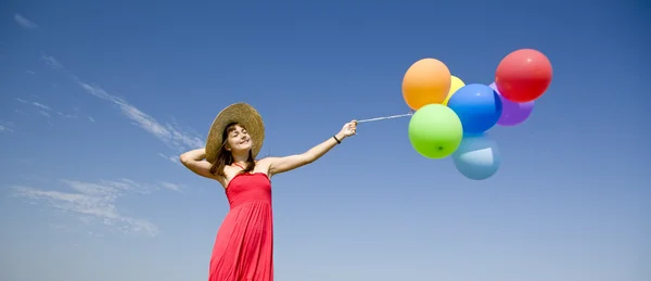 Bruna ragazza con palloncini di colore a sfondo cielo blu . — Foto Stock