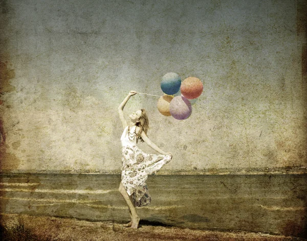 Κοκκινομάλλα κοπέλα με χρώμα μπαλόνια στην ακτή. — Φωτογραφία Αρχείου
