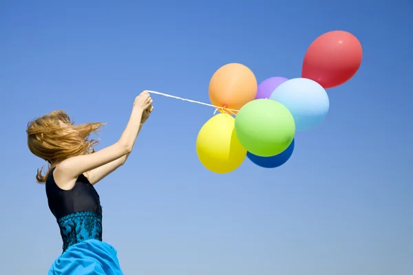 Rothaarige Mädchen mit bunten Luftballons am blauen Himmel Hintergrund. — Stockfoto