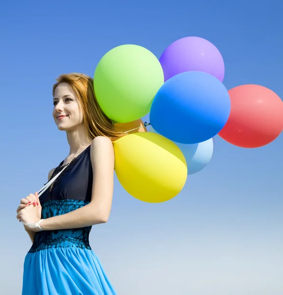 Kızıl saçlı kız mavi gökyüzü arka plan, renk balonlar ile. — Stok fotoğraf