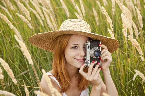 Roodharige meisje met oude camera op buiten. — Stockfoto