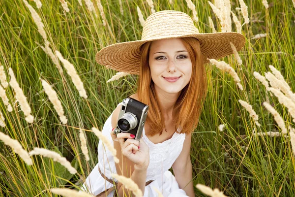 Roodharige meisje met oude camera op buiten. — Stockfoto