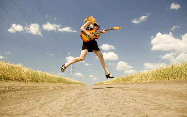 Menina de rock com guitarra no campo . — Fotografia de Stock