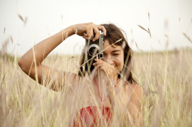 Brunette girl with camera at outdoor. clipart