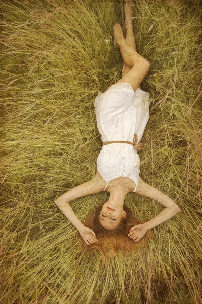 Beautiful girl lying down at grass. — Stock Photo, Image