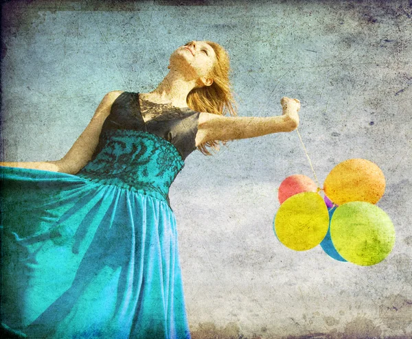 Рыжая девушка с цветными шариками на голубом фоне неба . — стоковое фото