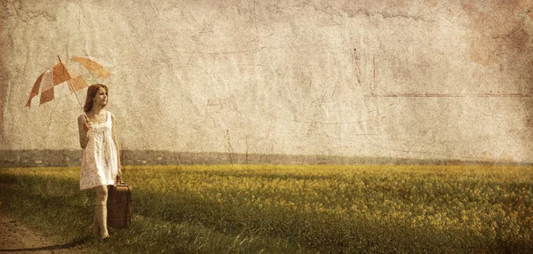 Encantadora pelirroja caminando cerca del campo de colza . —  Fotos de Stock