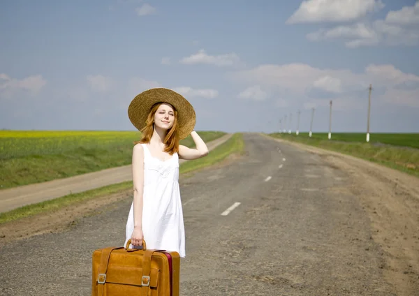 国の道路でスーツケースと孤独な少女. — ストック写真