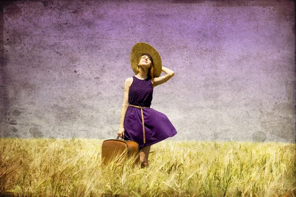 Eenzaam meisje met koffer op land. — Stockfoto