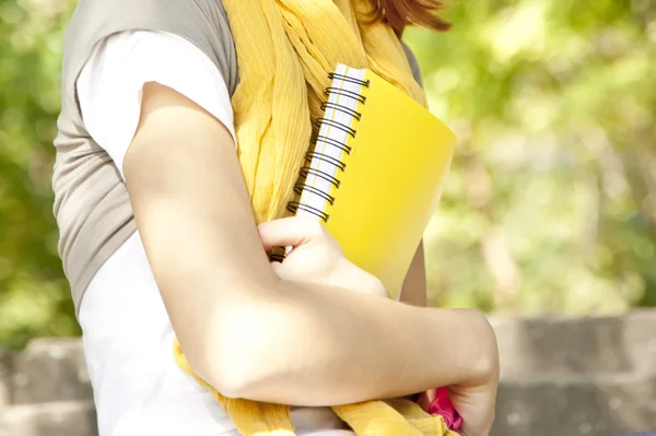 Student dívka ruce s notebookem na venkovní. — Stock fotografie