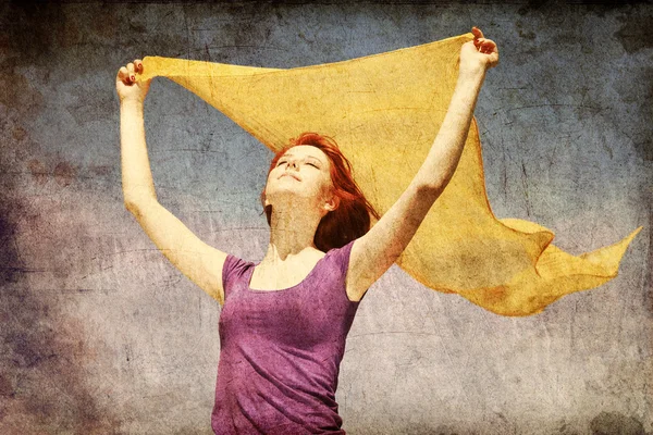 Ung kvinna med öppna armar hålla gul siden på vinden. — Stockfoto