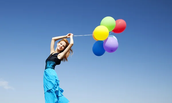 Menina ruiva com balões de cor no fundo do céu azul . — Fotografia de Stock
