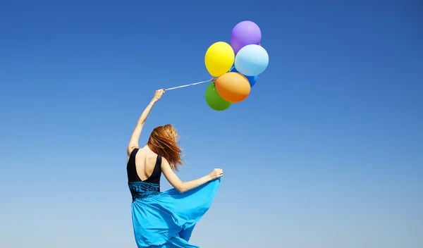 在蓝色的天空背景颜色气球的红发女孩. — 图库照片