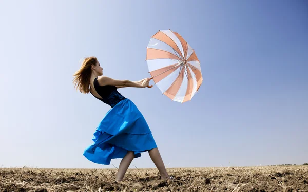 Redhead girl with umbrella at field. — Stock Photo, Image