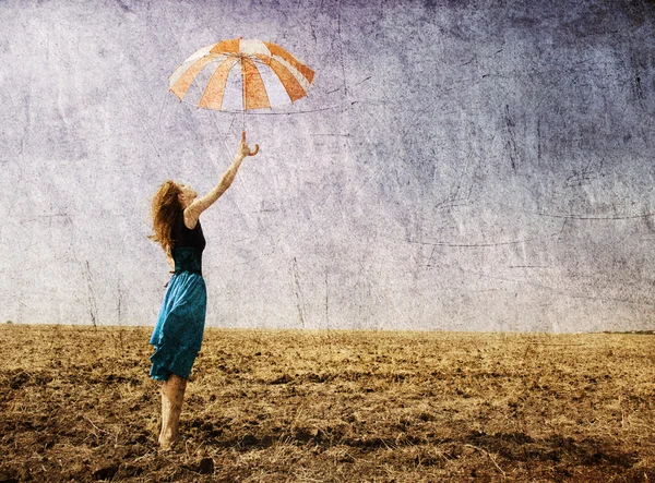 Redhead girl with umbrella at field. — Stock Photo, Image