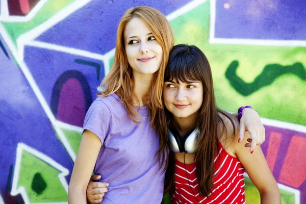 Twee meisjes in de buurt van graffiti muur. — Stockfoto