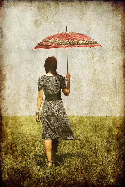 Rothaarige Mädchen mit Regenschirm auf Feld. — Stockfoto