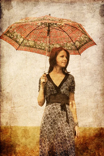 Rödhårig tjej med paraply på fältet. — Stockfoto