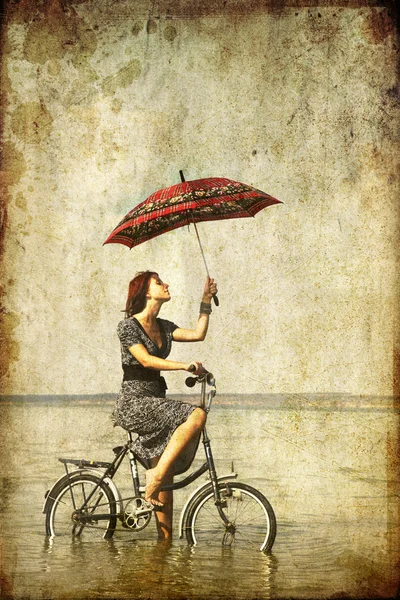 Girl with umbrella on bike. Photo in old image style. — Stock Photo, Image