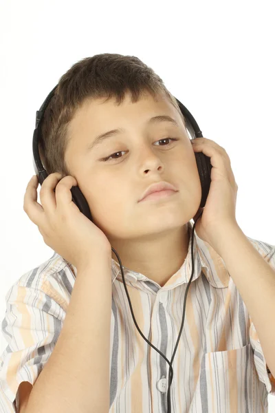 Мальчик в наушниках слушает музыку — стоковое фото