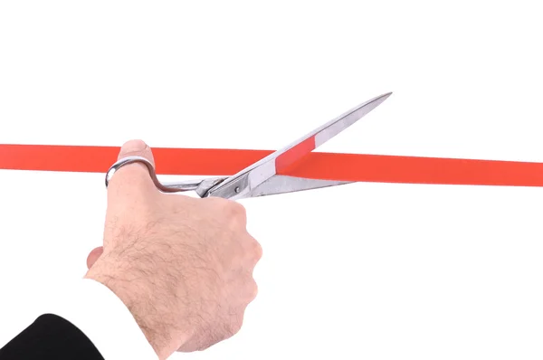 Ręce człowieka cięcia czerwoną wstążką z nożyczkami — Zdjęcie stockowe