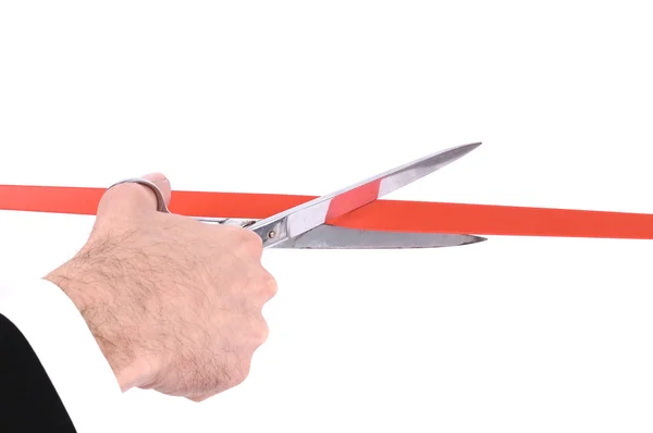Mano de hombre cortando una cinta roja con tijeras — Foto de Stock