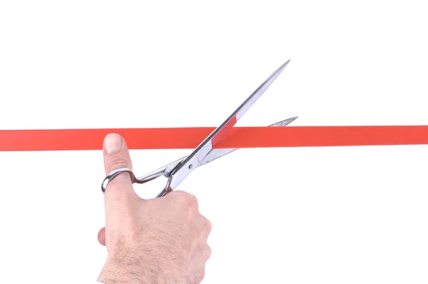 Primer plano de una mano de hombre cortando una cinta roja con tijeras —  Fotos de Stock