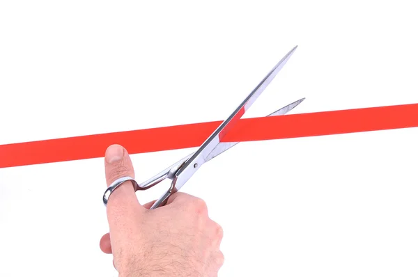 Die Hand eines Mannes schneidet mit einer Schere ein rotes Band durch — Stockfoto