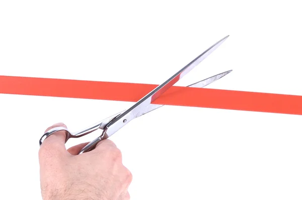 Primer plano de una mano de hombre cortando una cinta roja con tijeras —  Fotos de Stock