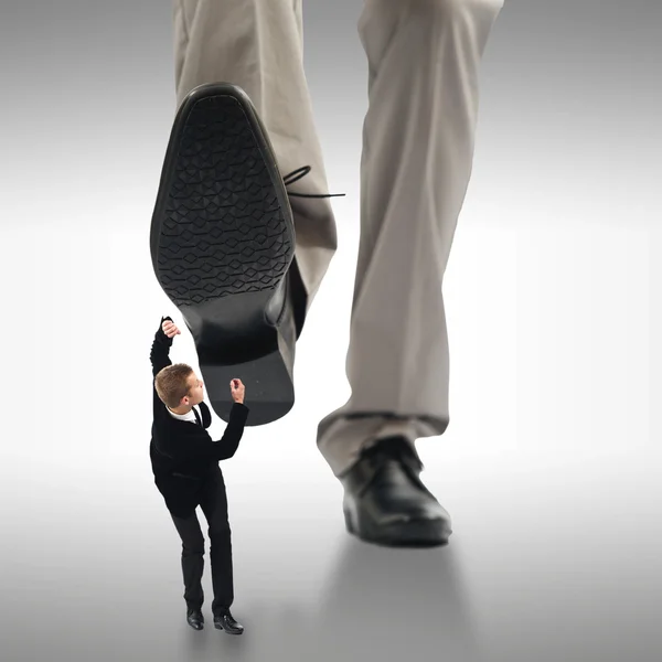 Piccolo uomo d'affari schiacciato dai piedi di un cespuglio gigante — Foto Stock