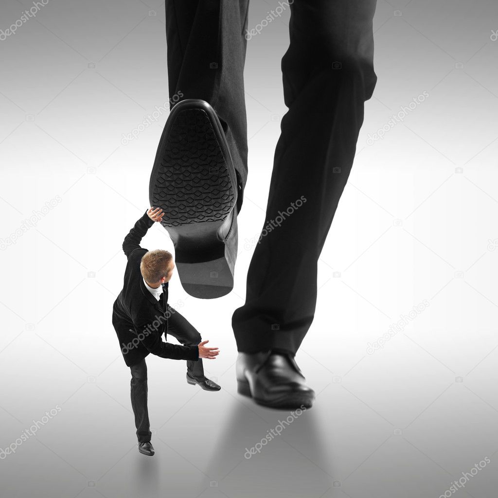 Little business man being crushed by the feet of a giant busines