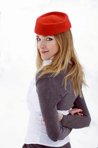 Красивая девушка в красной шляпе зимой — стоковое фото
