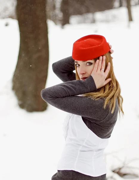Söt flicka i en röd hatt på vintern — Stockfoto