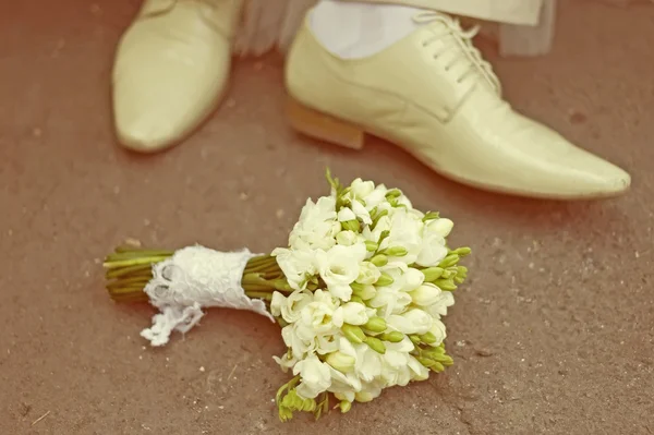 Bride\'s bouquet and groom\'s shoe