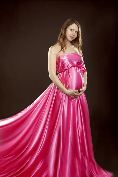 Красива вагітна дівчина в рожевій сукні — стокове фото