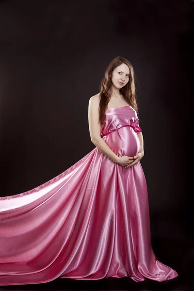 Vackra gravid flicka i en rosa klänning — Stockfoto