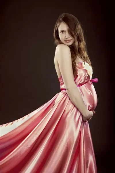 Krásná těhotná dívka v růžových šatech — Stock fotografie