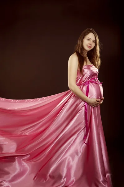 Vackra gravid flicka i en rosa klänning — Stockfoto