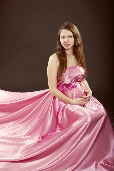 Bella ragazza incinta in un abito rosa — Foto Stock